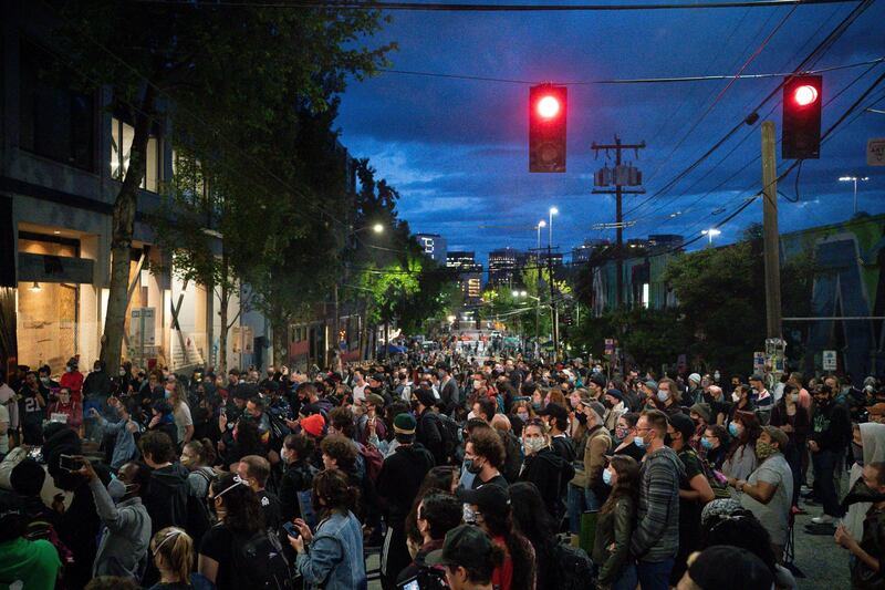 People listen as a band plays a free show in front of the Seattle Police Departments East Precinct in the so-called "Capitol Hill Autonomous Zone." Getty Images/AFP