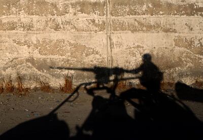 A picture taken on an army-organized press tour shows the silhouette of a Lebanese army soldier manning a machine gun in the Lebanese village of Ras Baalbek near the Syrian border on August 28, 2017. / AFP PHOTO / PATRICK BAZ