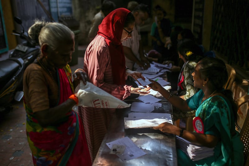 Voters present their documents at a polling station in Chennai, Tamil Nadu. Bloomberg