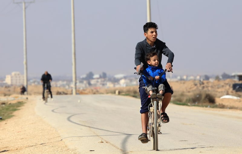 Syrian refugees ride their bicycles in the Zaatari camp, where a Covid-19 vaccination programme has begun. EPA