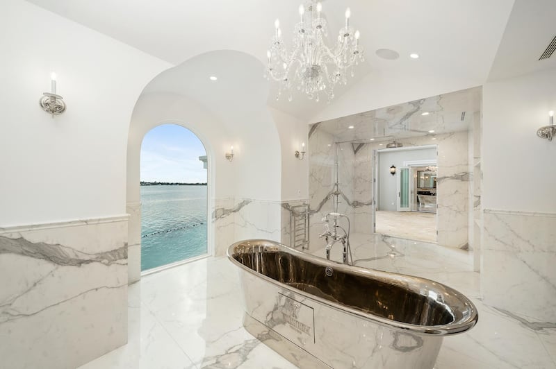 Master bathrooms are fitted with sunken bath tubs and rain showers. Courtesy Sotheby’s International Realty