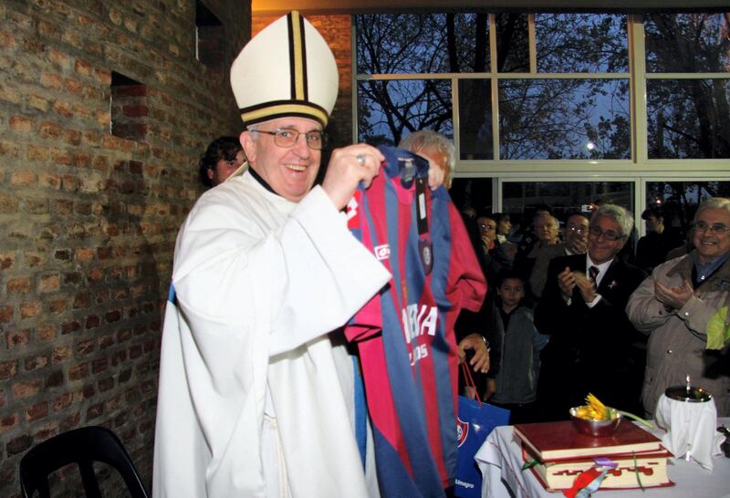 This May 24, 2011 file photo shows then cardinal Jorge Mario Bergoglio, now Pope Francis, posing with the jersey of San Lorenzo's football team, which he supports, in Buenos Aires. Bergoglio has been elected Pope on March 13, 2013, to replace the frail Benedict XVI as leader of the world's 1,2 billon Catholics. AFP PHOTO / Juan Ayala (Photo by Juan Ayala / AFP)