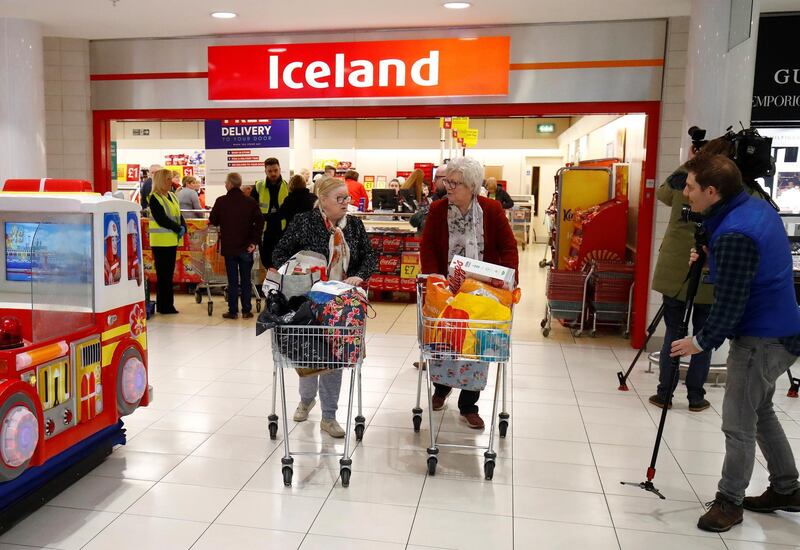 People with their shopping as they leave an Iceland store in the Kennedy Centre, in Belfast, Northern Ireland, Britain, March 17, 2020. Reuters