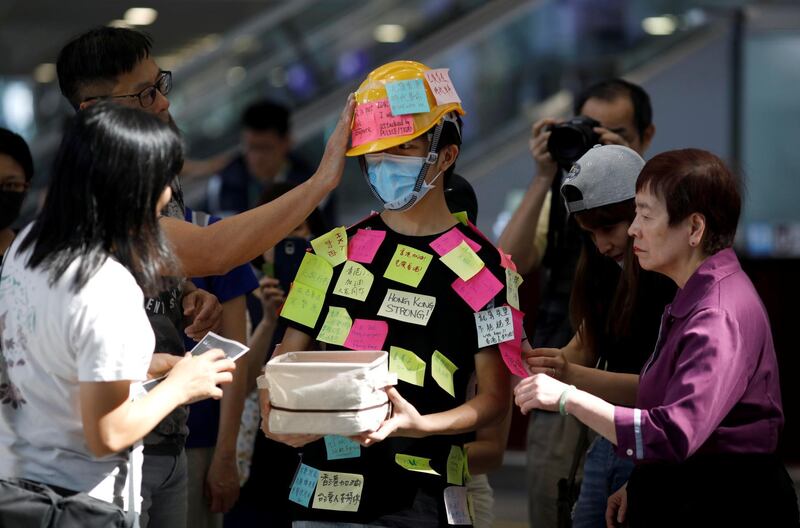 People paste post-it notes on a demonstrator. Reuters