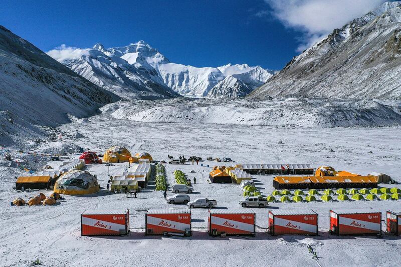 FILE - In this April 30, 2020, aerial file photo released by China's Xinhua News Agency, vehicles and tents are seen at the base camp at the foot of the Chinese side of the peak of Mount Qomolangma, also known as Mount Everest, in southwestern China's Tibet Autonomous Region. China has canceled attempts to climb Mount Everest from its side of the world's highest peak because of fears of importing COVID-19 cases from neighboring Nepal, state media reported. (Purbu Zhaxi/Xinhua via AP, File)