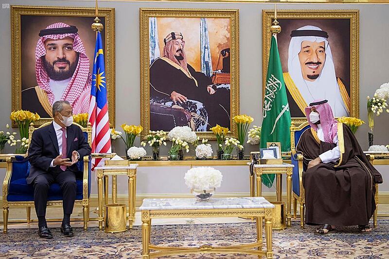 Saudi Crown Prince Mohammed bin Salman holds talks with Malaysian Prime Minister Muhyiddin Yassin, in Riyadh, Saudi Arabia. Portraits in the background show Saudi King Salman, right, Crown Prince Mohammed, left, and Saudi Arabia's founder King Abdulaziz Al Saud. SPA