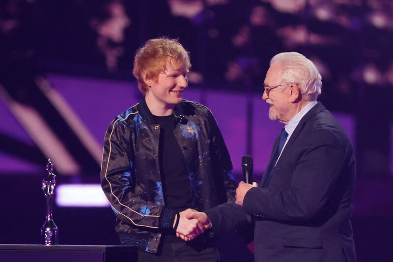 British singer and songwriter Ed Sheeran is congratulated by Scottish actor Brian Cox after receiving the Songwriter of the Year award. AFP