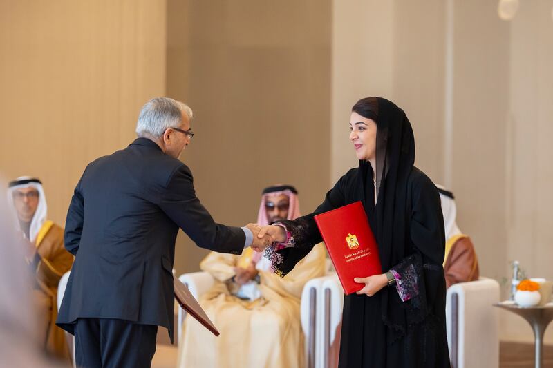 Reem Al Hashimy, Minister of State for International Co-operation, exchanges a document of agreement between India and the UAE, relating to the Bilateral Investment Treaty. Ryan Carter / Presidential Court