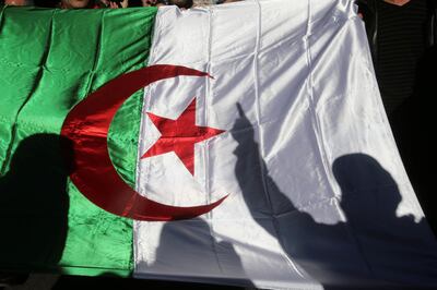 A demonstrator's shadow is cast on a national flag during an anti-government rally in Algiers, Algeria December 24, 2019. REUTERS/Ramzi Boudina