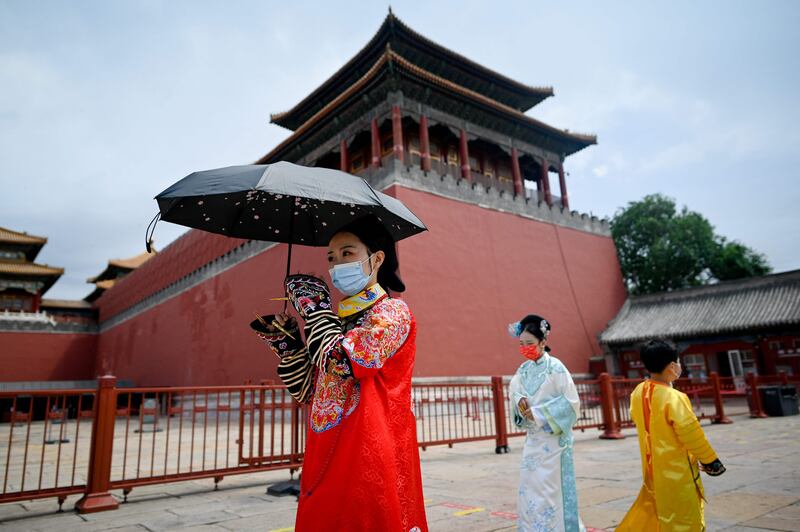 People wearing Chinese traditional dress prepare to visit the Forbidden City in Beijing after the government eased some Covid-19 restrictions. AFP