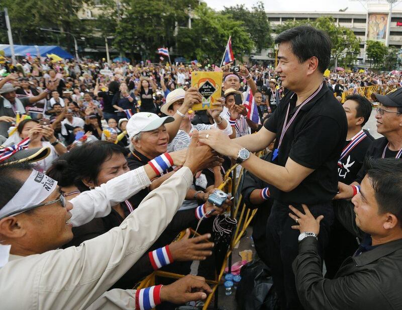 Former Thai Prime Minister and opposition Democrat Party leader Abhisit Vejjajiva, right, greets the anti-government protesters during a rally at Democracy Monument in Bangkok. Narong Sangnak / EPA