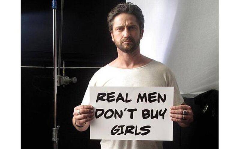 Gerard Butler holds up a sign reading Read Men Don’t Buy Girls in support of the movement. Courtesy Gerard Butler