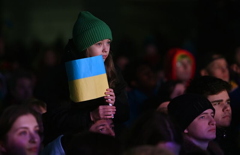 A young girl sits on her father's shoulders at the gathering. EPA