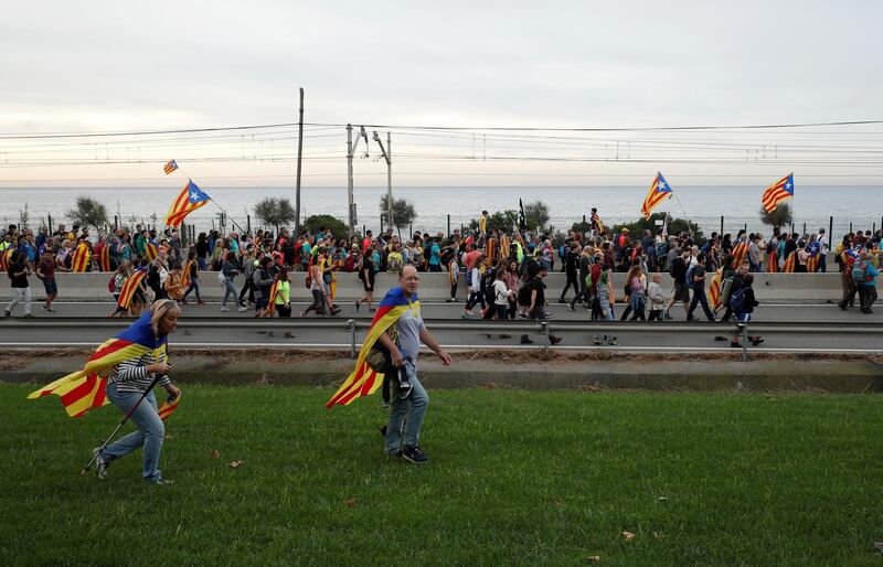 Catalan demonstrators wearing and waving Esteladas (Catalan separatist flags) chant slogans as they march during Catalonia's general strike in El Masnou, Spain, October 18, 2019. REUTERS/Albert Gea