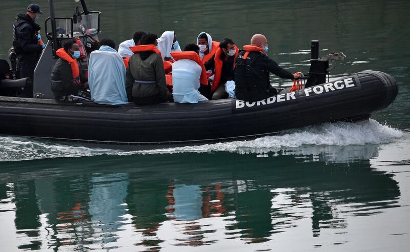 (FILES) In this file photo taken on August 15, 2020 UK Border Force officials travel in a RIB with migrants picked up at sea whilst Crossing the English Channel, as they arrive at the Marina in Dover, southeast England on August 15, 2020. The British government on on March 24, 2021 launched plans for what it said would be the biggest overhaul of asylum rules in decades, saying the current system was "overwhelmed". / AFP / Ben STANSALL
