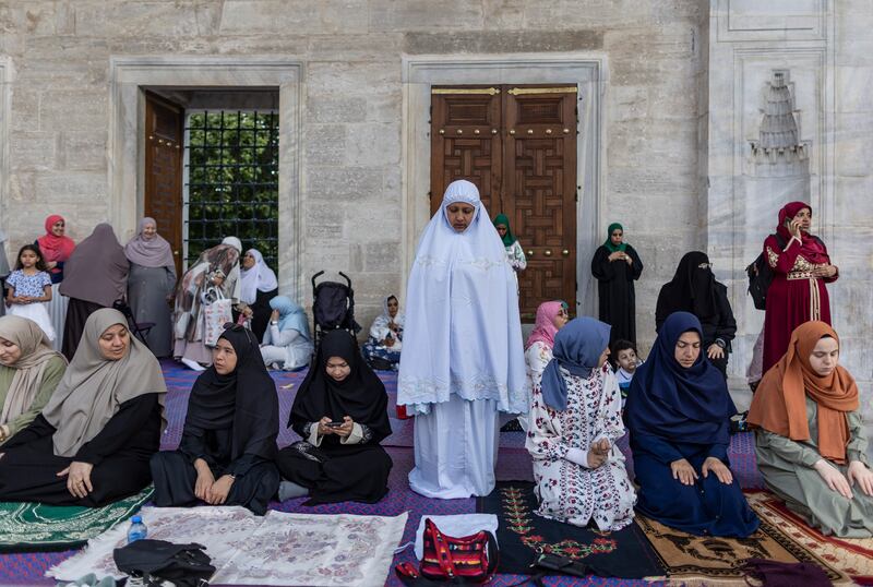 Muslim women pray in a courtyard of the Blue Mosque in Istanbul. EPA