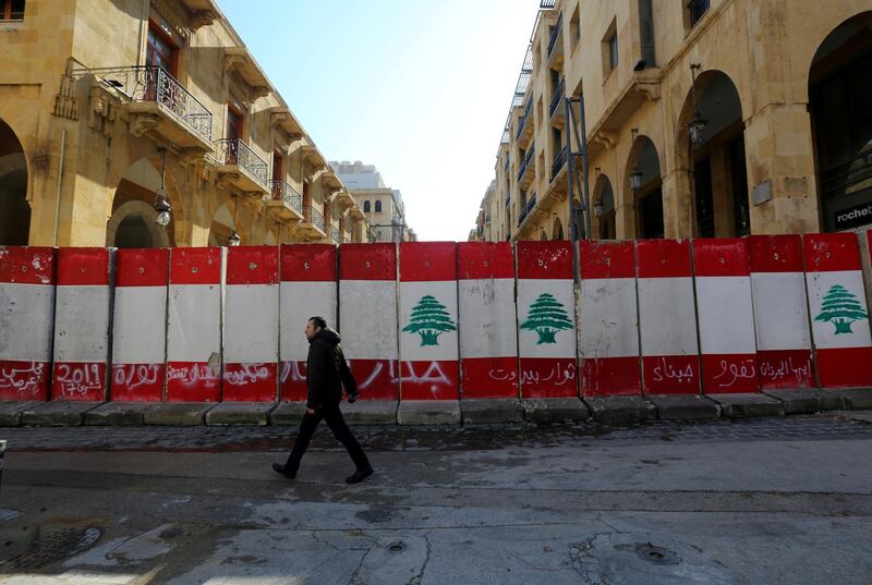 FILE PHOTO: A man walks past concrete barriers erected by authorities to block a street leading to the parliament building in Beirut, Lebanon January 24, 2020. REUTERS/Aziz Taher/File Photo