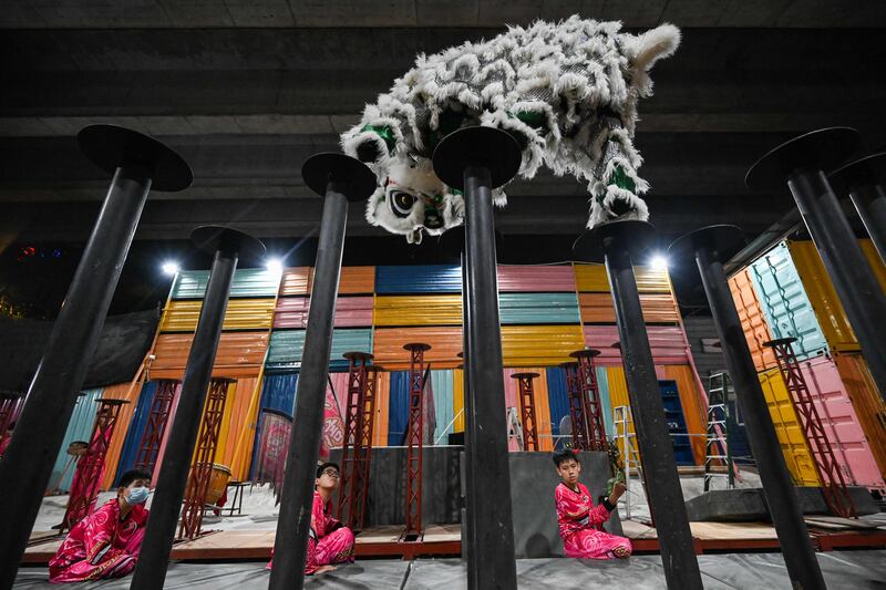 Members of a lion dance troupe practising on high poles ahead of celebrations for the Lunar New Year of the Rabbit in Kuala Lumpur.  AFP