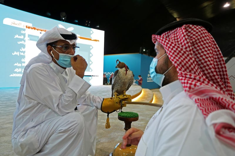 A Saudi man wearing a mask carries a falcon for an auction at Saudi Falcons Club Auction in Riyadh. Ahmed Yosri / Reuters