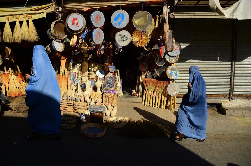 Afghan women walk through a market in Herat. Hoshang Hashimi / AFP