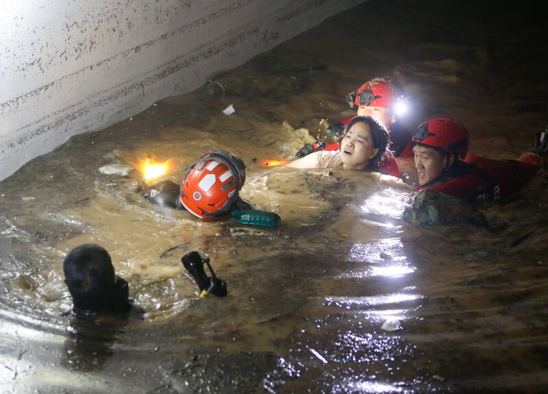 Firefighters and military officials rescue one of the missing residents from the underground parking lot of an apartment building which was submerged in heavy rain caused by Typhoon Hinnamno, in Pohang, South Korea, on September 7, 2022.  EPA