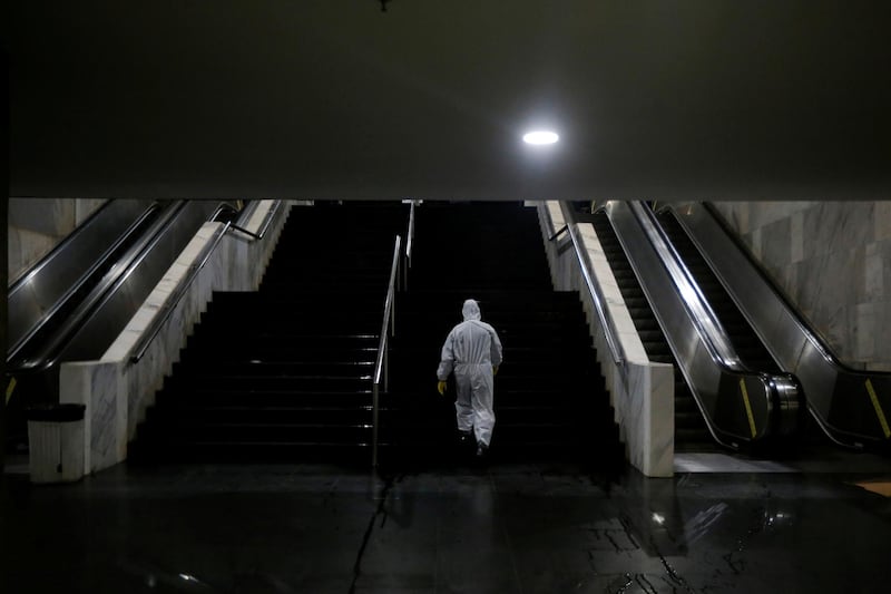 A member of the armed forces wearing a protective suit walks after disinfecting the Metro's Central station in Brasilia, Brazil. Reuters