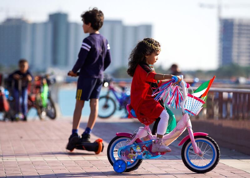 Abu Dhabi, United Arab Emirates, December, 2, 2020.   Children on their scooters with UAE flags and other UAE Day paraphernalia along ther Corniche.Victor Besa/The NationalSection:  National News