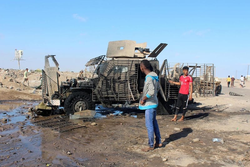 Yemenis inspect a burnt armored vehicle after a suicide bomber rammed his explosives-laden vehicle into an area where security forces and pro-government militiamen had assembled on February 29, 2016 in the residential Sheikh Othman district of Aden. AFP / SALEH AL-OBEIDI

