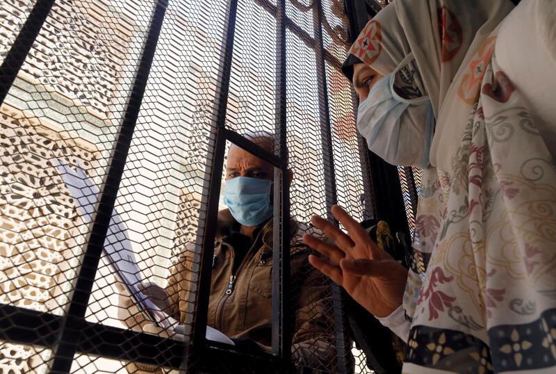 A man who is in contact with people who have contracted the coronavirus wears a protective face mask as he receives through iron bars the free medicines provided by the ministry of health, at a medical centre in Cairo, Egypt. Reuters