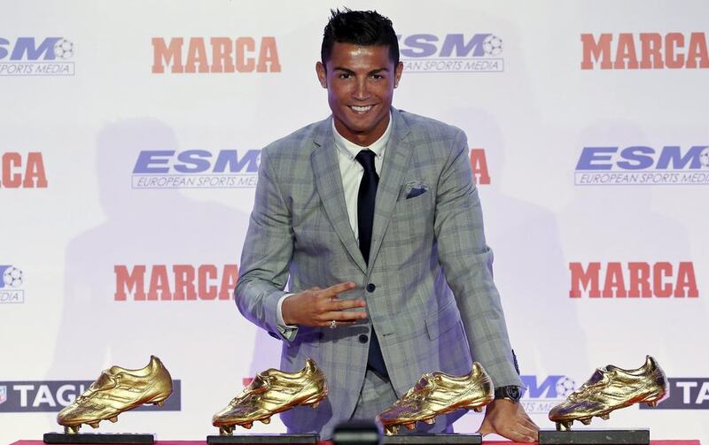 Real Madrid striker Cristiano Ronaldo poses in front of his four Golden Boot trophies during a ceremony in Madrid, Spain, October 13, 2015. REUTERS/Andrea Comas