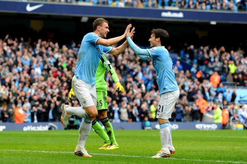 Edin Dzeko of Manchester City is congratulated by teammate David Silva after scoring his team's third goal past goalkeeper Paulo Gazzaniga of Southampton during the Premier League match between Manchester City and Southampton at Etihad Stadium on April 5, 2014 in Manchester, England. Chris Brunskill / Getty Images