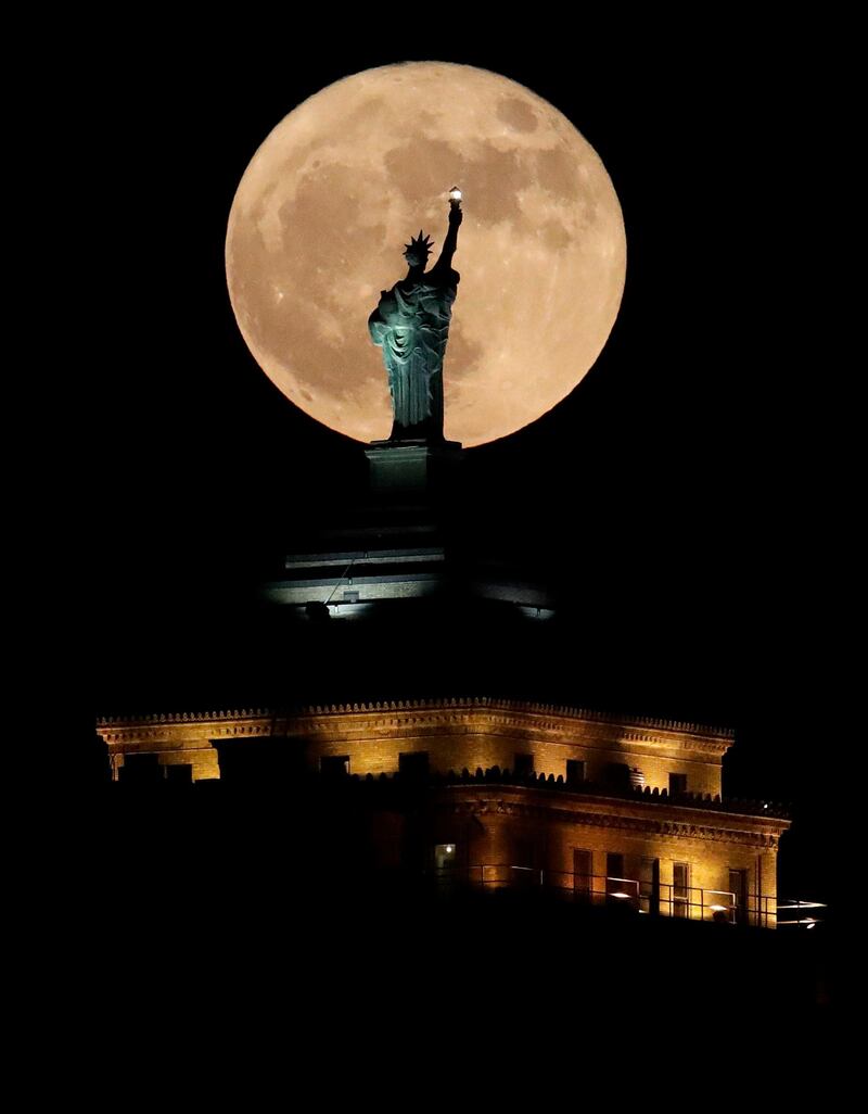 A supermoon rises in front of a replica of the Statue of Liberty sitting atop the Liberty Building in Downtown Buffalo, New York. Julio Cortez / AP Photo