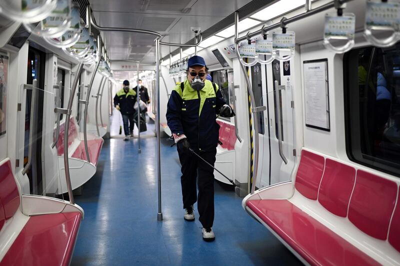 A staff member sprays disinfectant in a subway train compartment in Beijing.  AFP