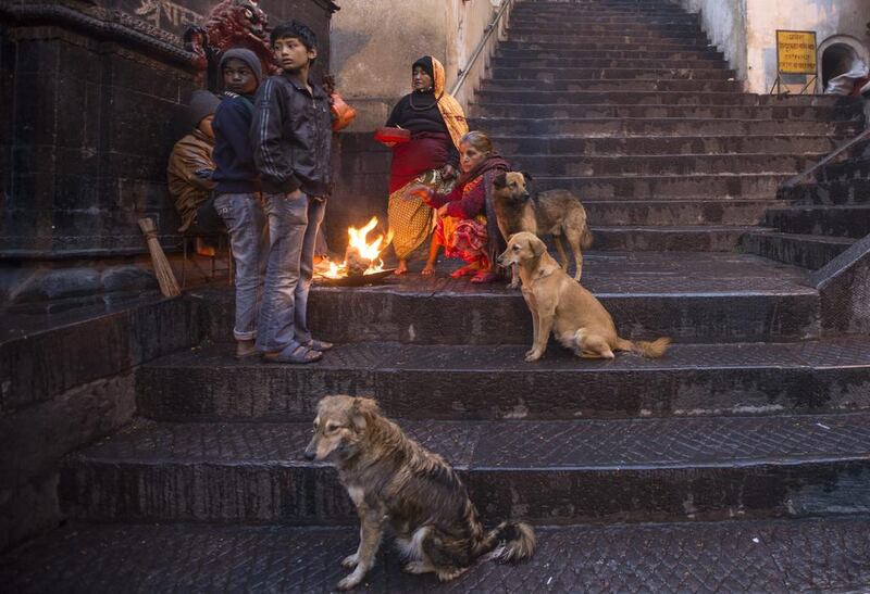 Nepalese women and children warm themselves by a fire on a winter morning at Pashupati Temple in Kathmandu, Nepal. Narendra Shrestha / EPA