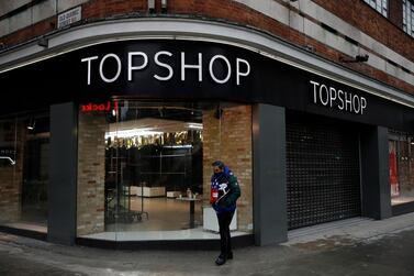 A man wearing a face mask to curb the spread of coronavirus walks past a closed branch of Topshop where Old Quebec Street joins Oxford Street, in London. AP