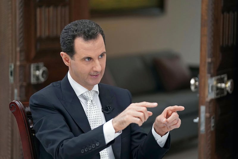 FILE - In this file photo released May 10, 2018, by the Syrian official news agency SANA, Syrian President Bashar Assad speaks during an interview with the Greek Kathimerini newspaper, in Damascus, Syria. In an interview with Russia Today television which aired Thursday, May 31, 2018, Assad said that the U.S. troops, who operate air bases and outposts in the Kurdish-administered region, will have to leave the country. Assad threatened to attack the region held by U.S.-backed Kurdish fighters in northeastern Syria if talks fail to bring the area back under Damascusâ€™ authority. (SANA via AP)