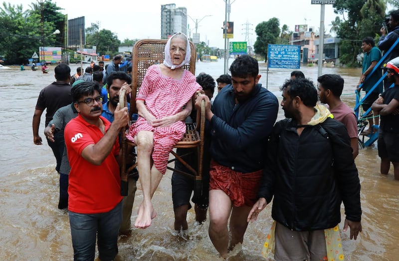 Volunteers and rescue personal evacuate local residents in Ernakulam district. AFP