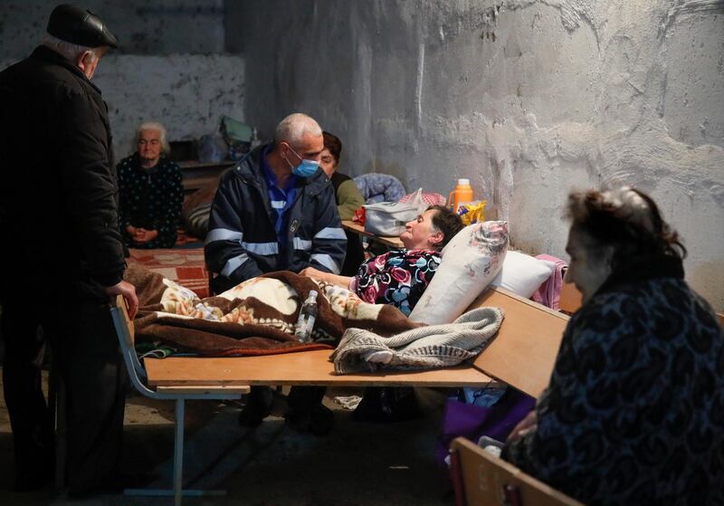 A medical worker talks to a sick woman in a bomb shelter in Stepanakert, the separatist region of Nagorno-Karabakh, Thursday, Oct. 22, 2020. Heavy fighting over Nagorno-Karabakh continued Thursday with Armenia and Azerbaijan trading blame for new attacks, hostilities that raised the threat of Turkey and Russia being drawn into the conflict. (AP Photo)
