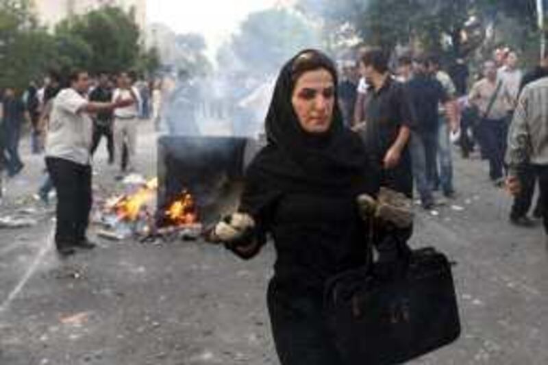 FILE - In this Saturday, June 20, 2009 file photo posted on the internet, an Iranian woman carries rocks at an anti-government protest in Tehran, Iran. In a part of the Muslim world where women are often perceived of as the repressed gender, images of Iranian women during and after the recent elections have catapulted Iran's female demonstrators into the forefront of the country's opposition movement. (AP Photo, File) *** Local Caption ***  ABC114_Mideast_Iran_Women_at_the_Front.jpg