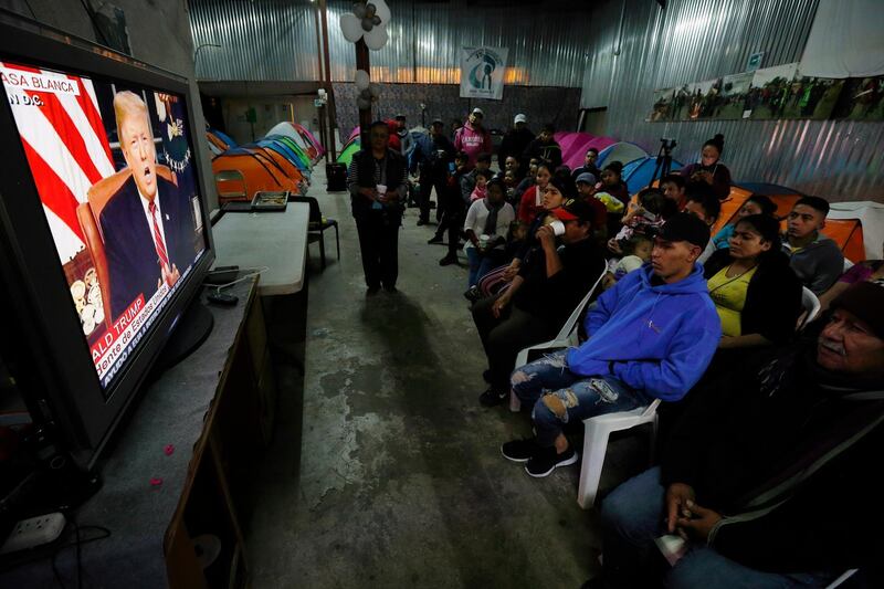 Migrants mainly from Mexico and Central America watch from a shelter in Tijuana, Mexico, as Donald Trump speaks. AP Photo