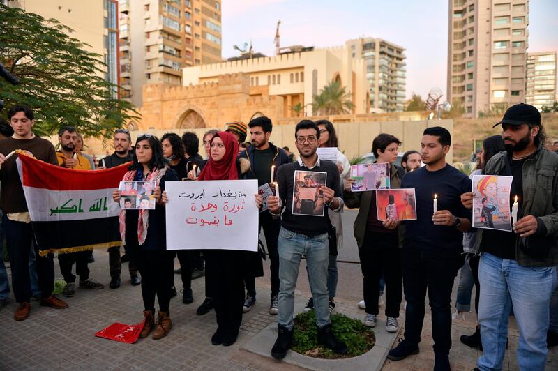 Lebanese activists hold candles during a protest to support children taking part in the uprising in front of the Iraqi embassy in Beirut.  EPA