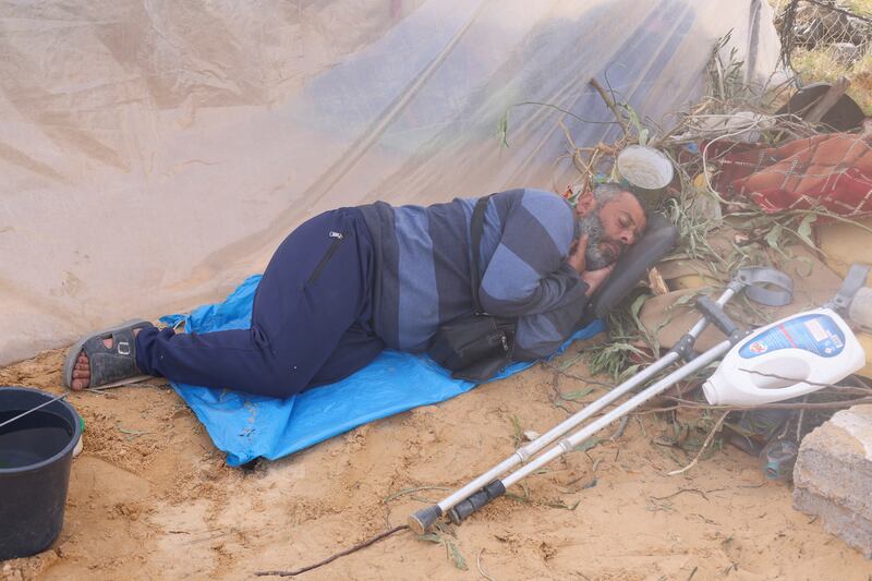 A displaced Palestinian, who fled his home from Israeli strikes, grabs some sleep at a camp in Rafah in the southern Gaza Strip. Reuters