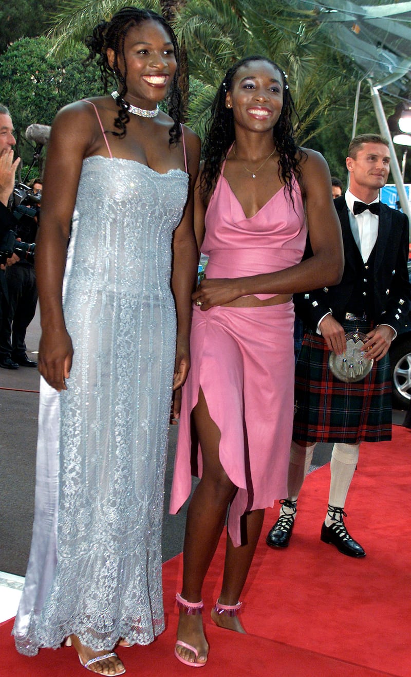 Serena Williams, in a silver dress, and Venus Williams arrive to attend the Laureus World Sports Awards in Monte Carlo, Monaco on May 25, 2000. Reuters