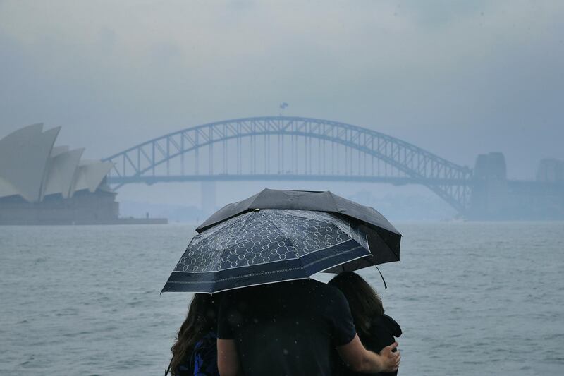 Tourists are seen looking at The Sydney Harbour Bridge in the rain in Sydney, Australia. A severe thunderstorm warning has been issued for some parts of Sydney as the city experiences its wettest day in four months. The rain is welcome relief after months of bushfires which have been burning across NSW. Getty Images