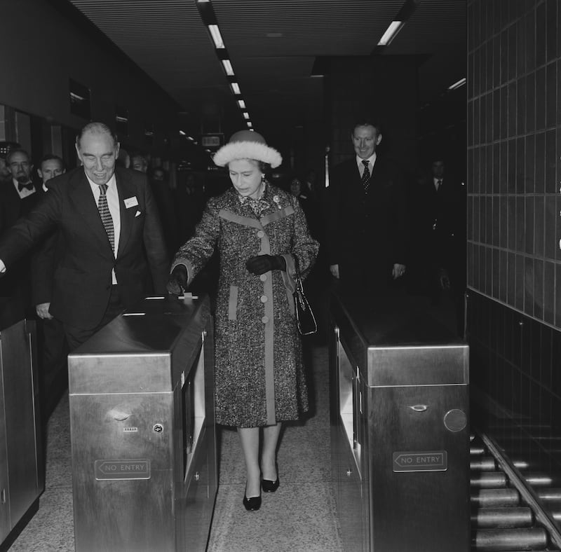 Queen Elizabeth II passing though the Tube gates at Heathrow Central station on its opening in 1977