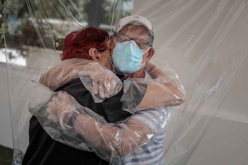 A woman embraces her nephew  through a plastic device after three months without a hug at a home for the elderly in Valencia, Spain.  EPA