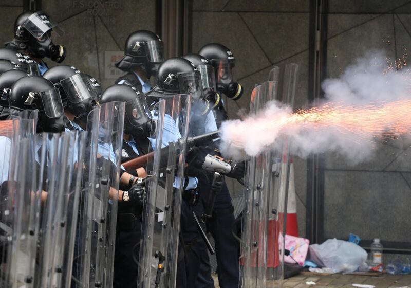 Police officers fire tear gas at protesters. Reuters