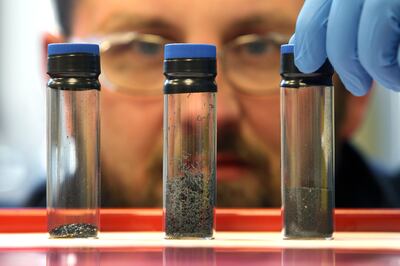 Scientist examines the progression of graphene in three vials. Getty