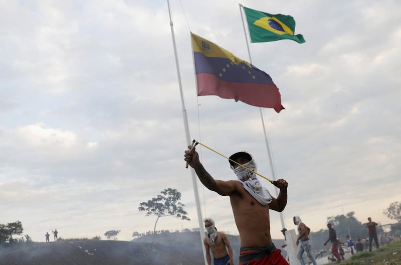 A protester uses a slingshot during clashes with Venezuelan soldiers along the border between Venezuela and Brazil. Reuters