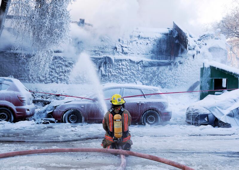 Firefighters battle a five-alarm fire in an apartment building in Montreal. AP

